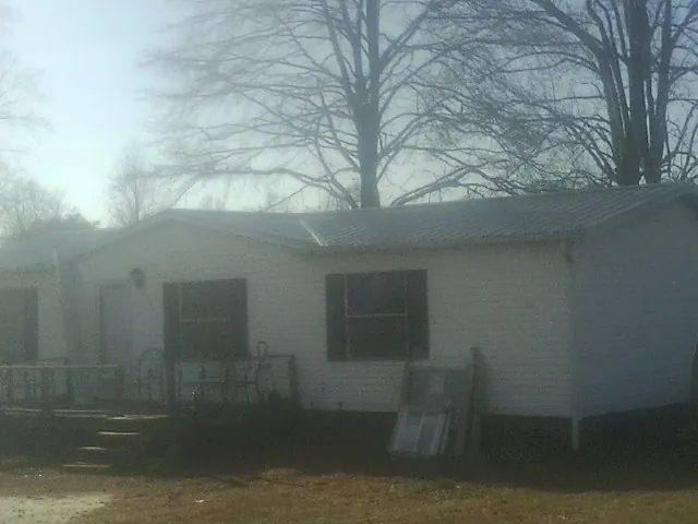 New metal roof on a white painted brick home on a foggy morning in Kindred