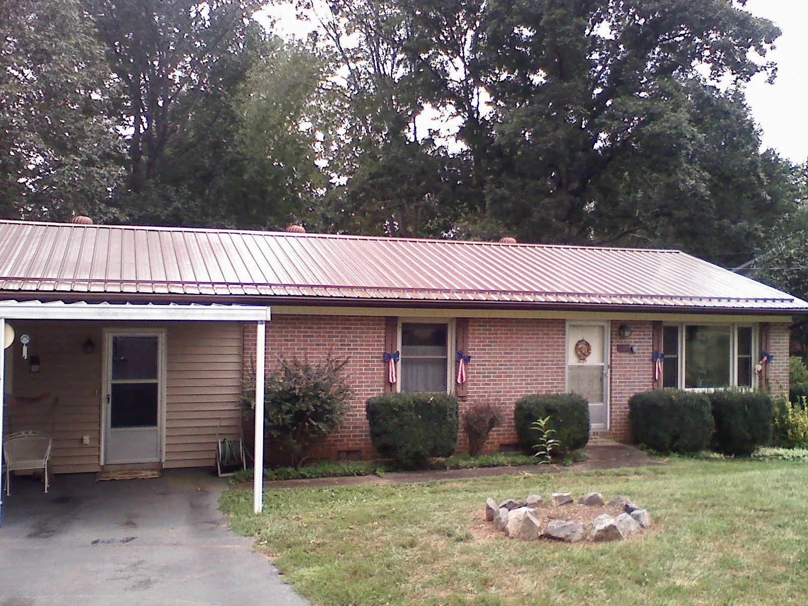 Bronze metal roof and carport on a brick ranch home — Roof Repair work by our crew in Kindred