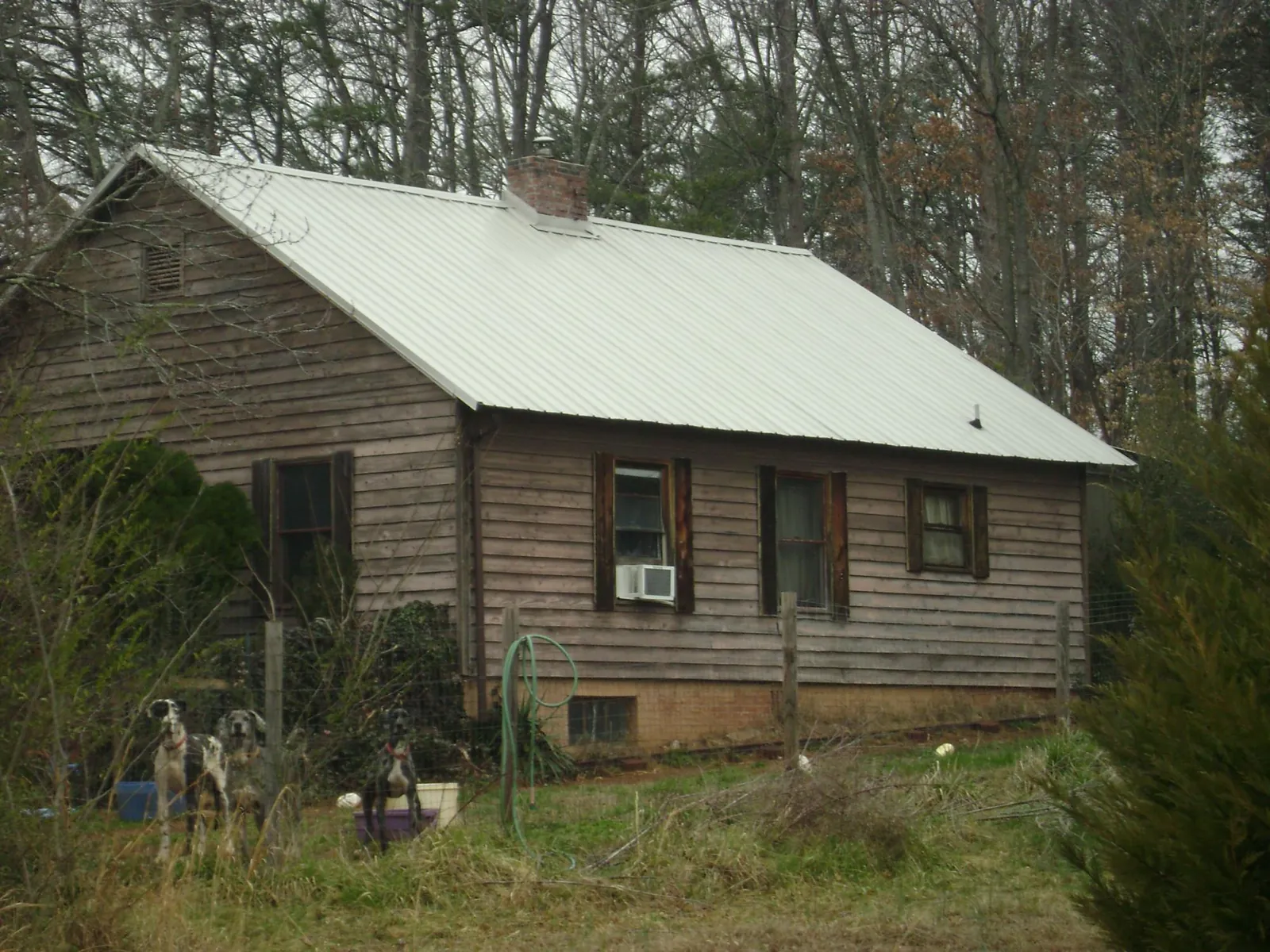 White metal roof on an old wood sided farmhouse, from a Metal Roof Installation job in Kindred